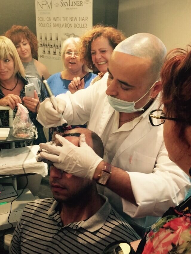 משה אלול מדגים טיפול הדמיית שיער בקרקפת (Hair Follicle Simulation) באמצעות מכשיר ייעודי
