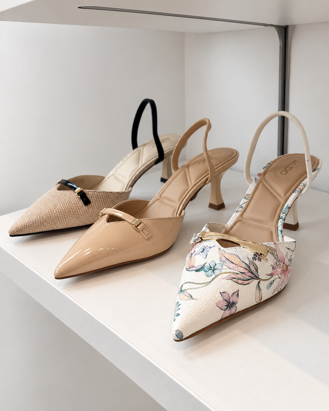A nude ALDO pump and a floral print pump on a display shelf.