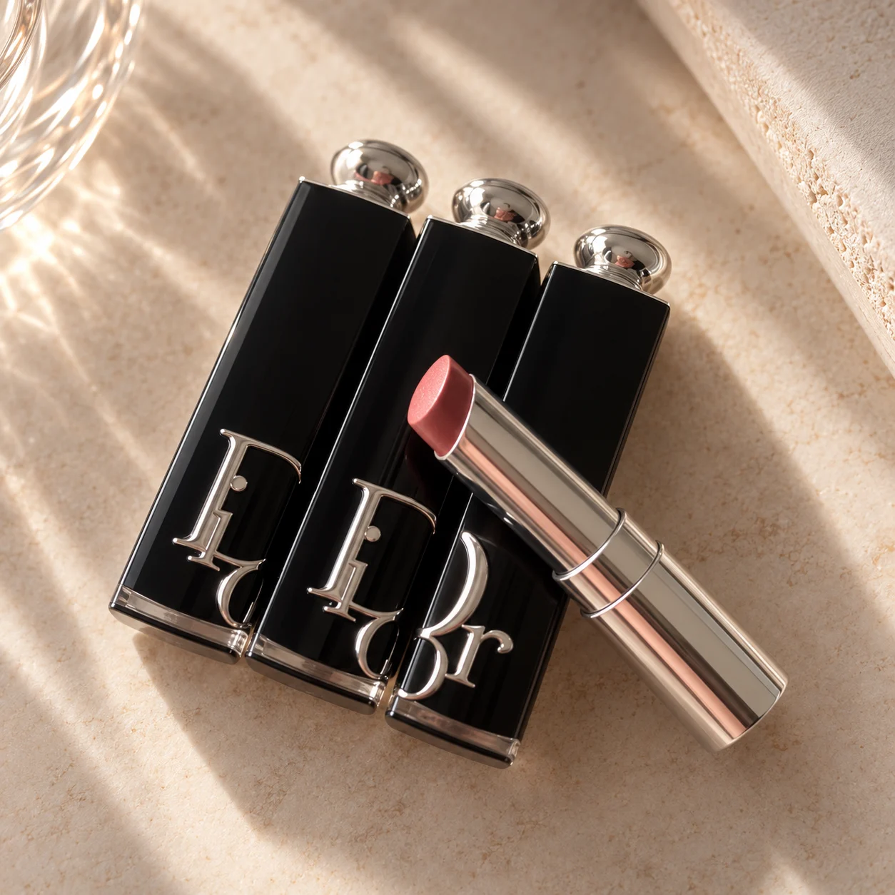 Dior Addict Hydrating Shine lipsticks, one open showing a nude shade.