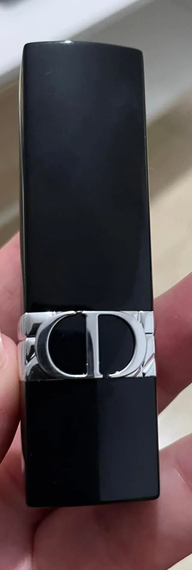 A Dior Addict lipstick held in hand, from Michal Loren's professional kit.