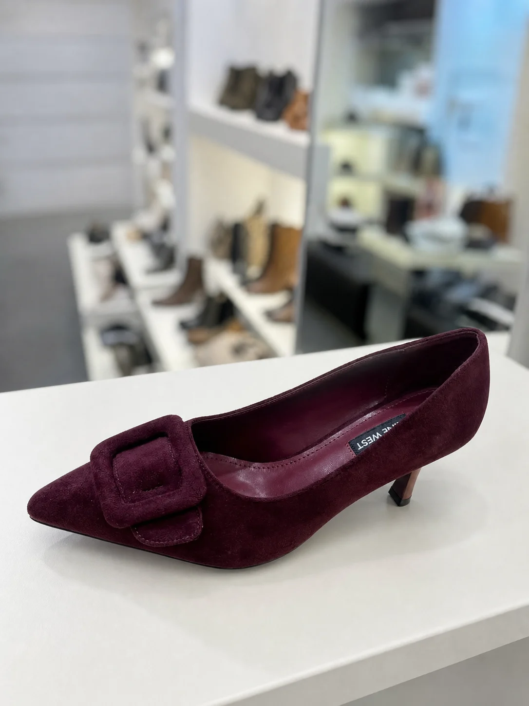 נעל עקב מזמש בבורדו עם אבזם גדול של Nine West על מדף