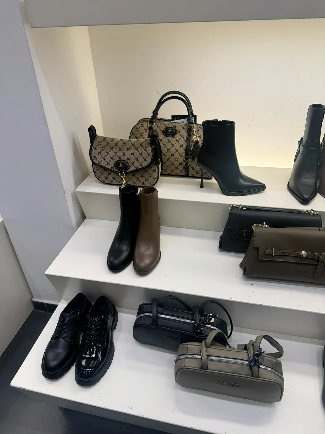 תיקים בהדפס מונוגרמה ומגפונים בחנות Nine West