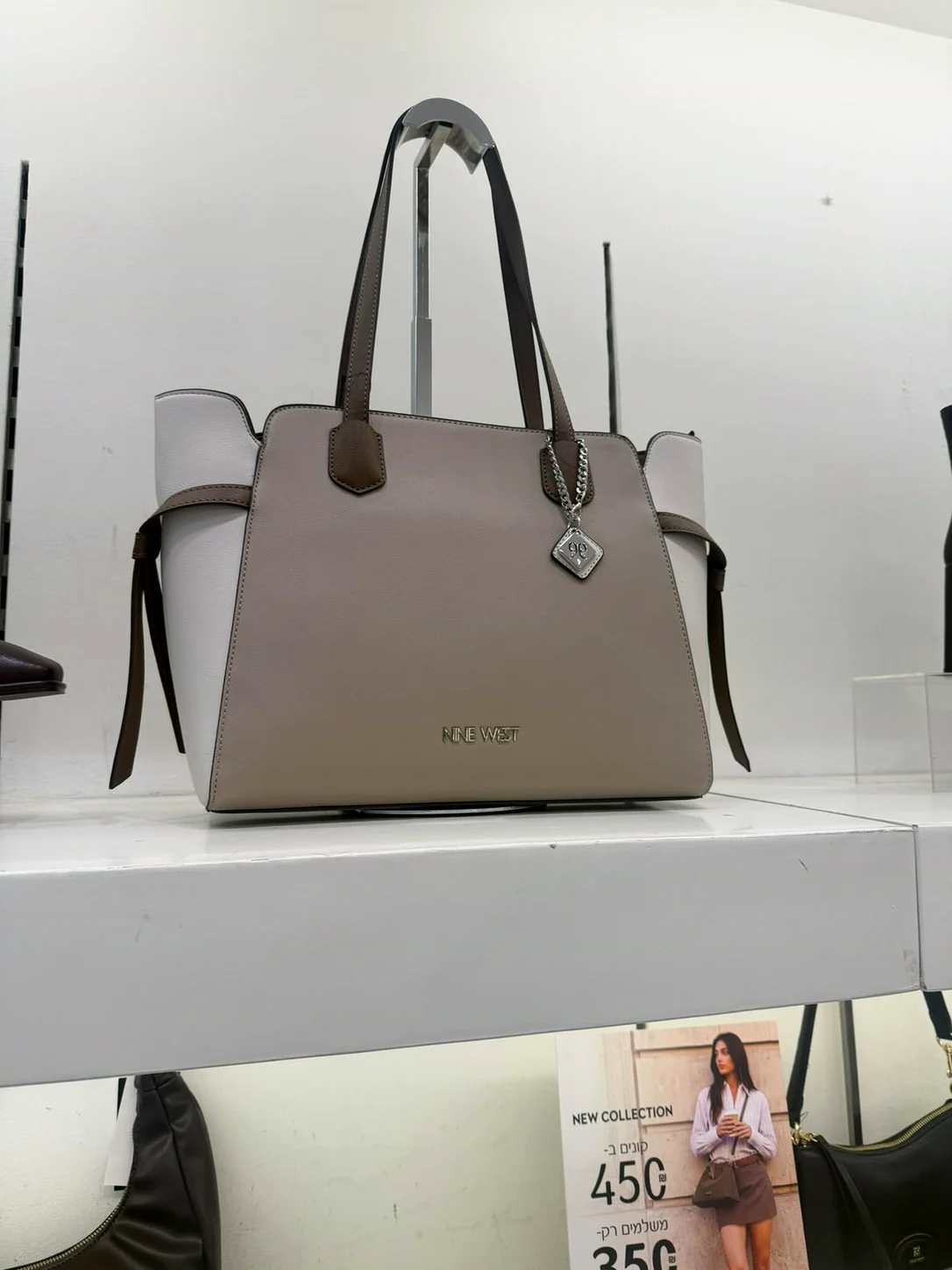 תיק טוט בגוון טאופ על מדף בחנות Nine West