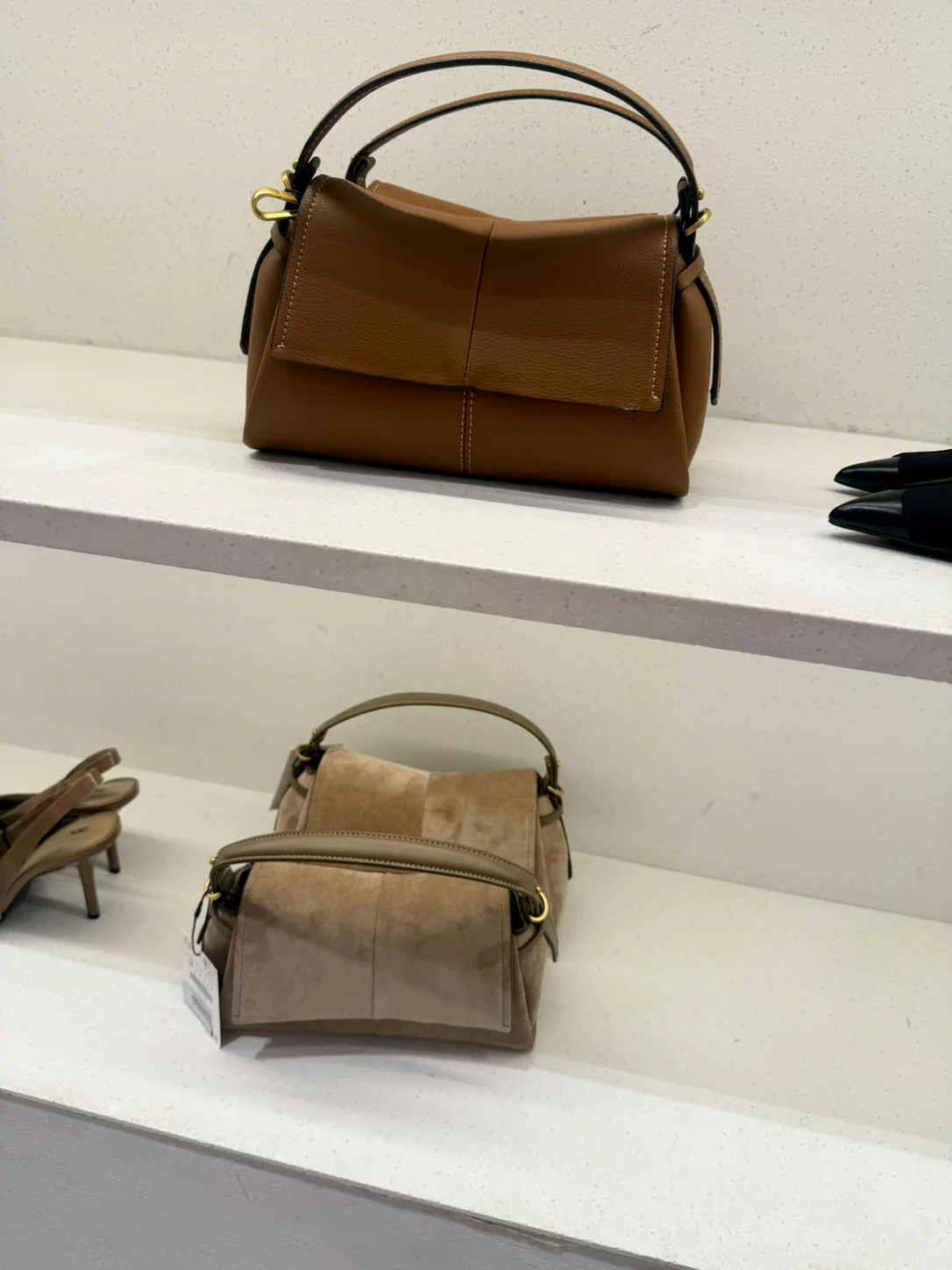 תיקי עור חומים על מדף בחנות Zara