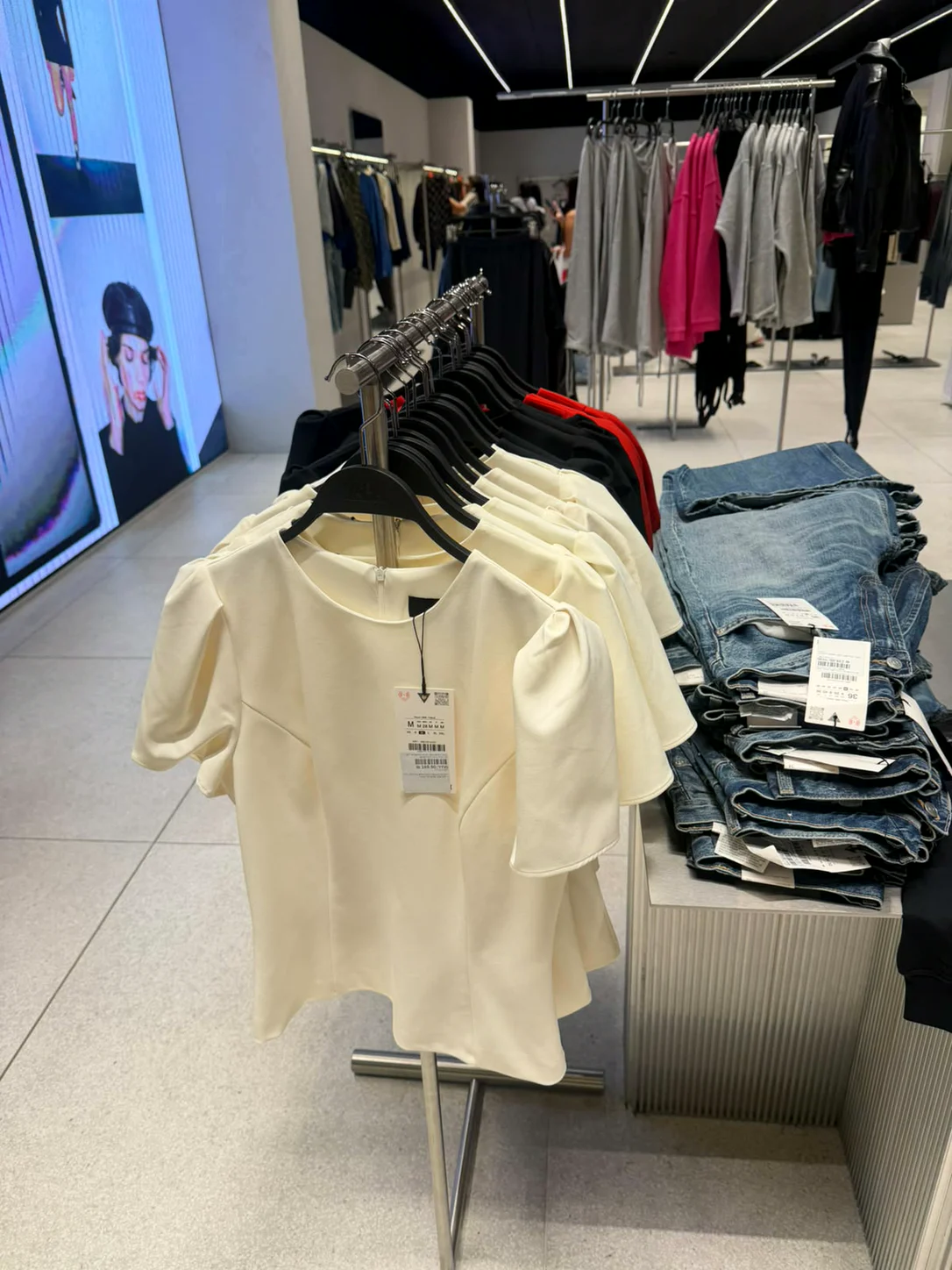 חולצות בגוון שמנת וג׳ינסים בחנות Zara