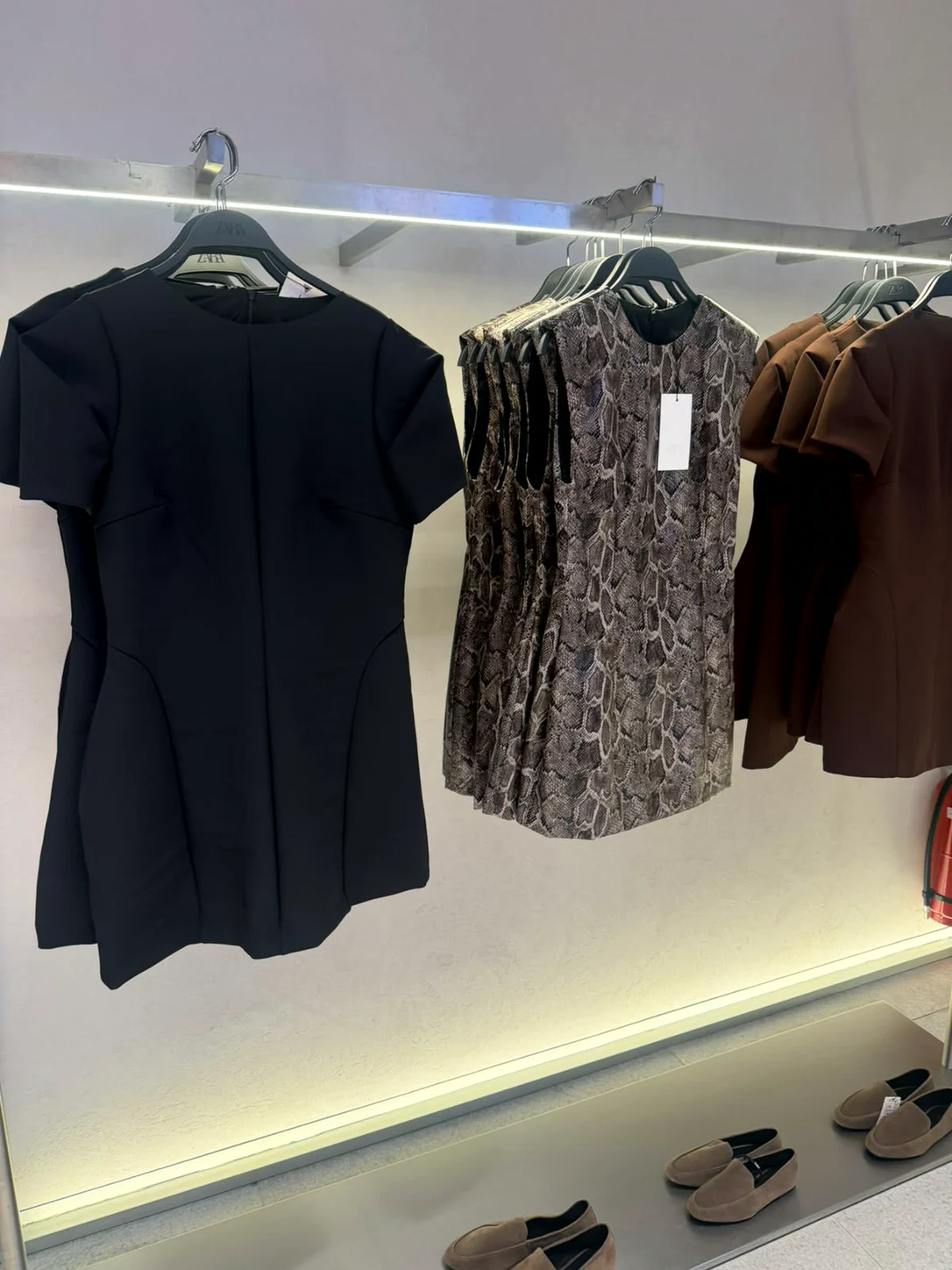 שמלות קצרות בכחול כהה ובהדפס על מתלה בחנות Zara