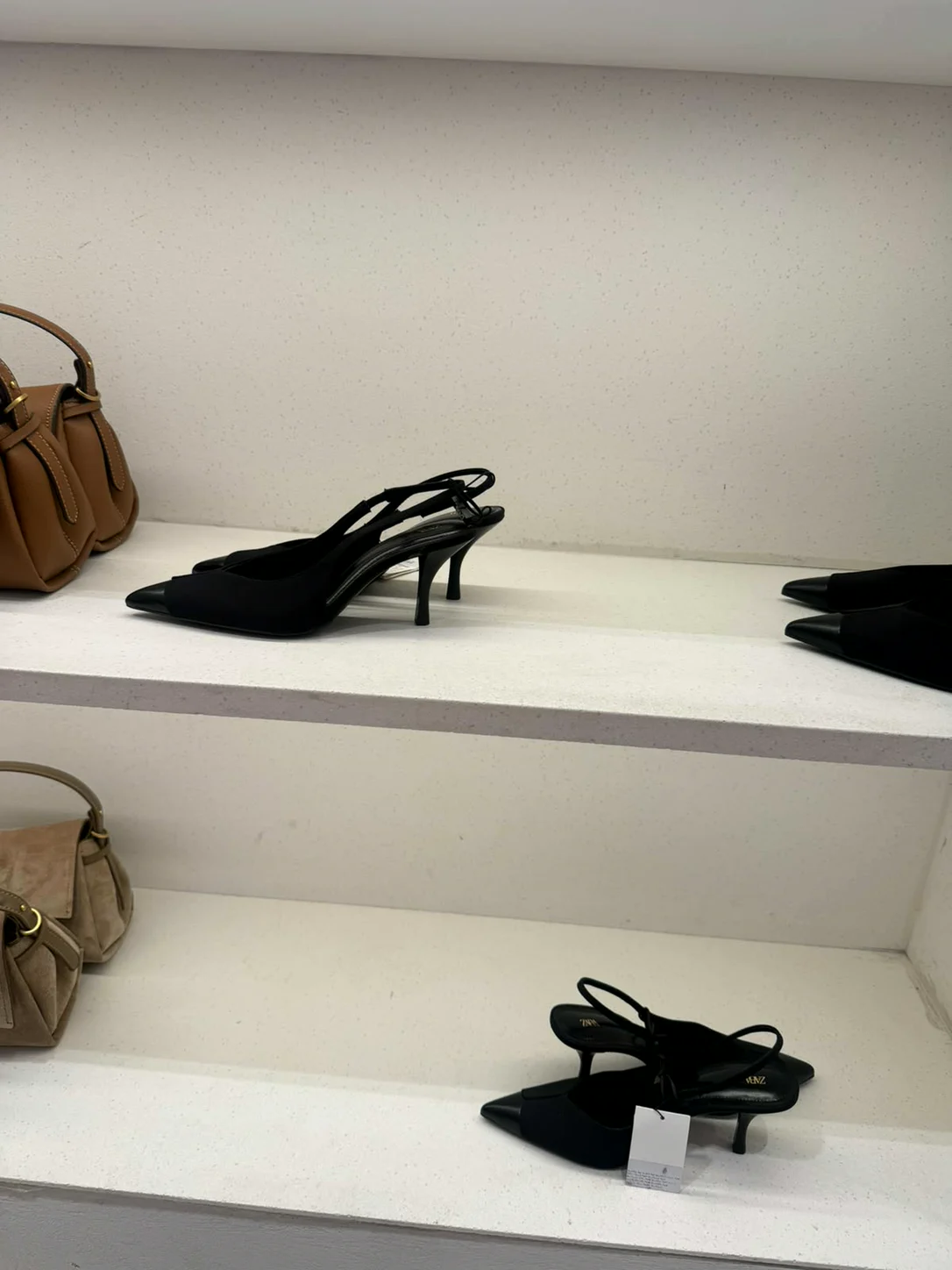 נעלי סלינגבק שחורות ותיקים על מדפים בחנות Zara